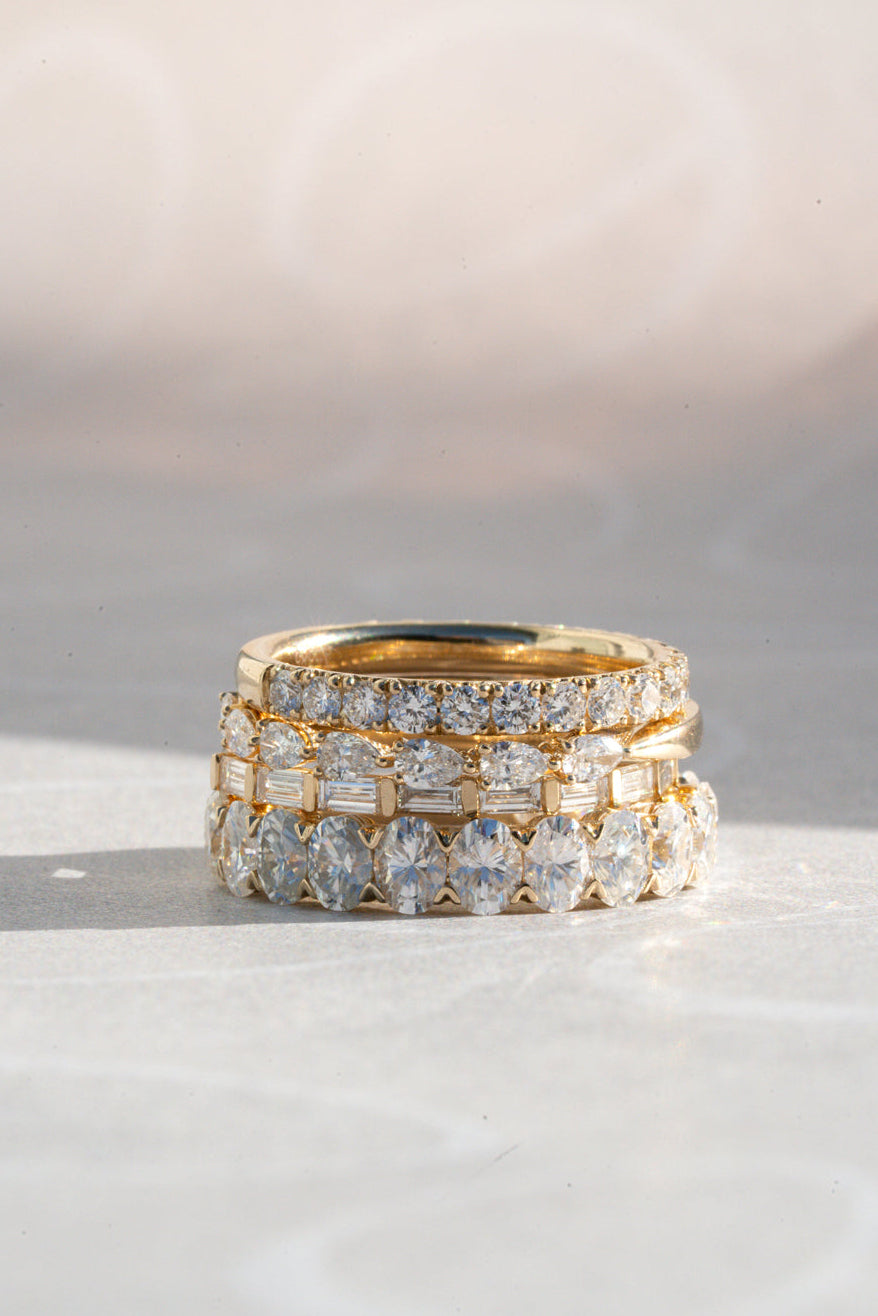 Stack of gold and diamond rings on a light background